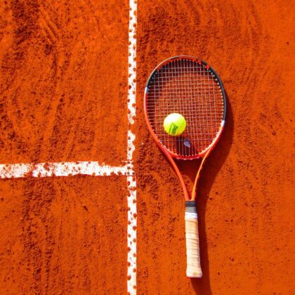 Raquette de tennis et balle sur terre battue